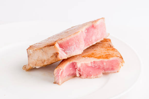 grilled tuna fish steak on a white plate with a place for garnish