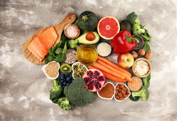 istock Healthy food clean eating selection: fish, fruit, vegetable, cereal, leaf vegetable on rustic background 1210193506
