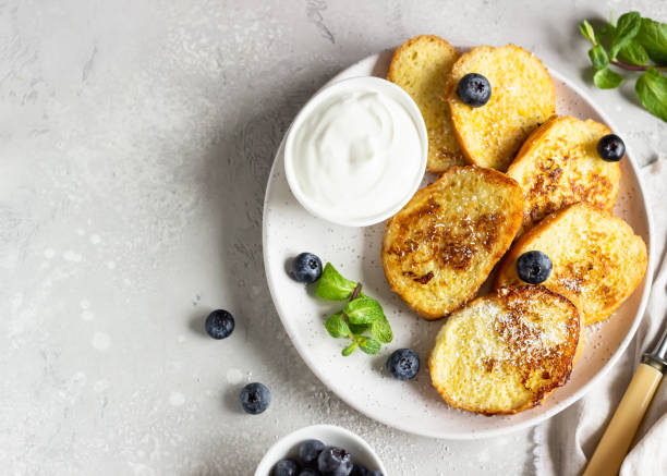 tostadas tradicionales españolas fritas, torrijas, con arándano y menta sobre un plato de cerámica. postre típico para cuaresma y pascua. vista superior. - french toast breakfast food fruit fotografías e imágenes de stock