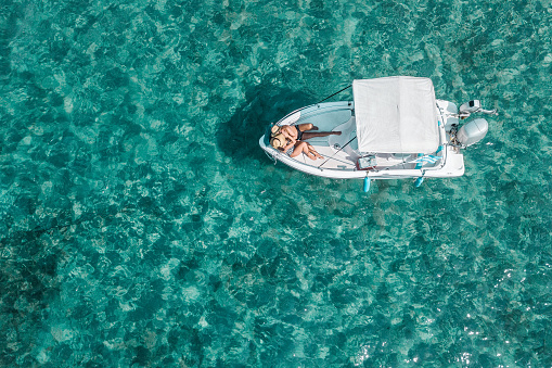 Aerial view of a young couple enjoying a sunny day on the boat