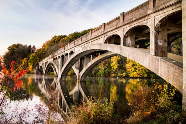 Photo of Cement bridge over smooth water in autumn