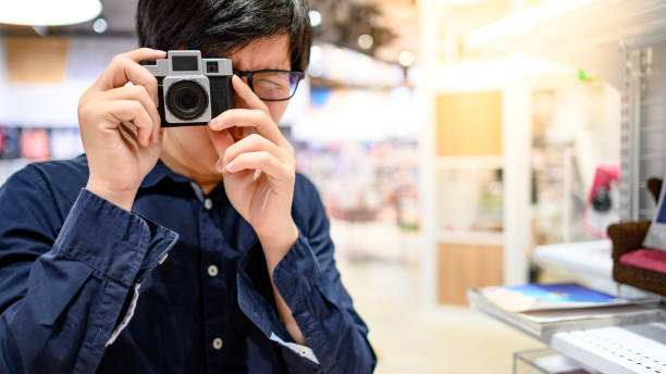 istock Asian man using small film camera taking photo 1210196409