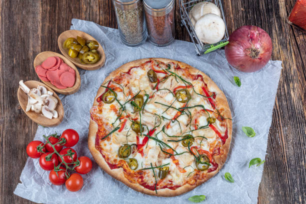 istock Chicken Pizza. Pizza with chicken and vegetables on wooden background 1210201778