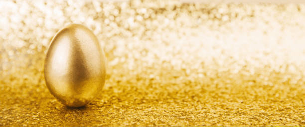Golden egg on shiny glitter yellow background