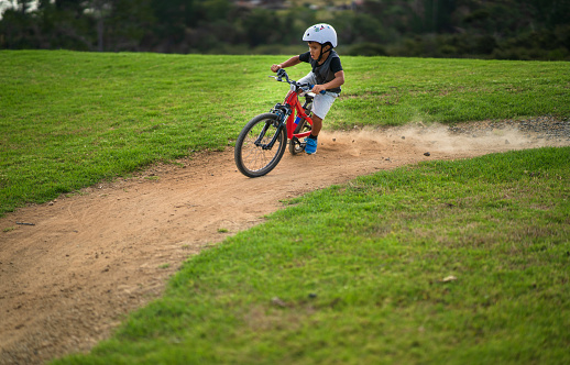 Kid having fun while skidding on his bike on a bike track in Auckland, New Zealand.