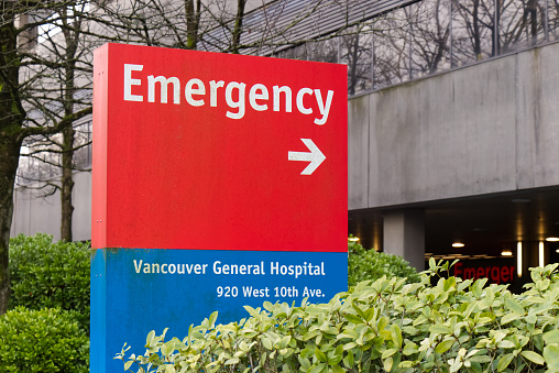 Vancouver, Canada - February 17, 2020: Close up view of Vancouver General Hospital emergency sign in red with directional arrow points towards the emergency room entrance
