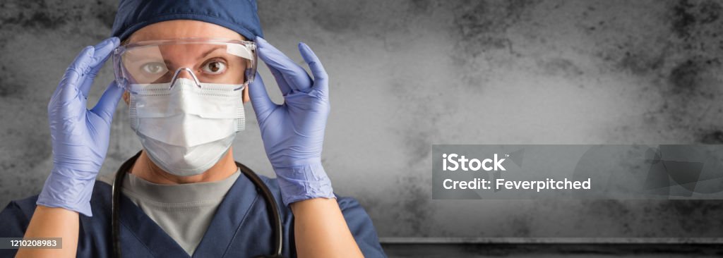 Female Doctor or Nurse Wearing Scrubs and Protective Mask and Goggles Banner Female Doctor or Nurse Wearing Scrubs and Protective Mask and Goggles Banner. Protective Workwear Stock Photo