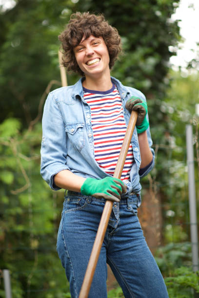 istock smiling woman gardener with tools in garden 1210217382