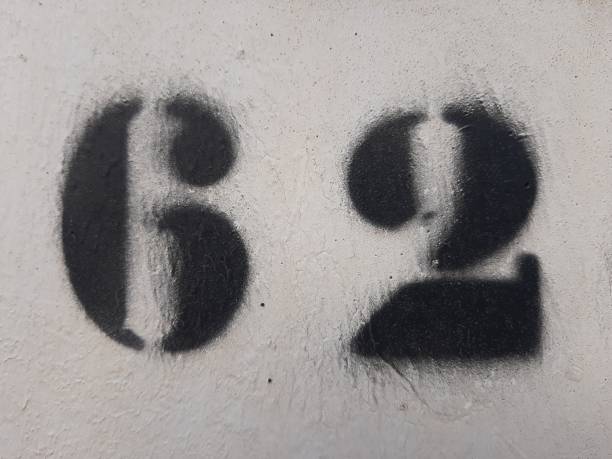 istock Number sixty two painted stencil on concrete wall, number 62 1210218121