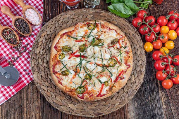 istock Chicken Pizza. Pizza with chicken and vegetables on wooden background 1210219921