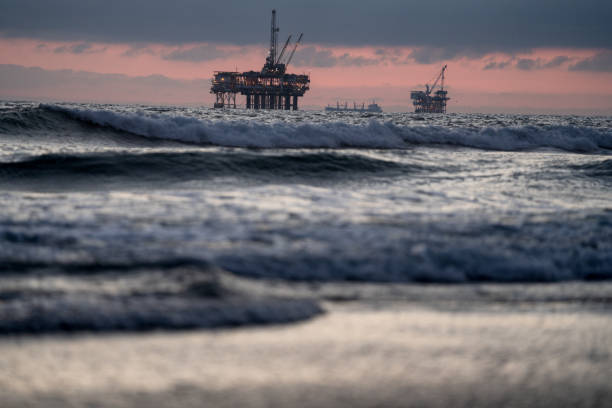 istock Offshore Oil and Gas Fracking and Drilling Rig with the Pacific Ocean in front and a beautiful sunset behind it with dramatic clouds 1210222882