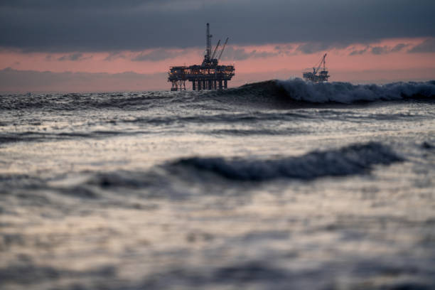 istock Offshore Oil and Gas Fracking and Drilling Rig with the Pacific Ocean in front and a beautiful sunset behind it with dramatic clouds 1210222933