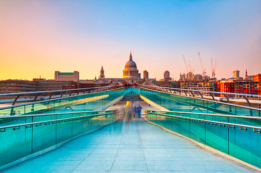 Blurred motion view over the Millennium footbridge looking towards St. Paul's Cathedral at sunset