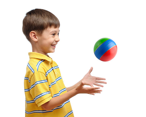 Purple beach ball in a child's hands against the sky