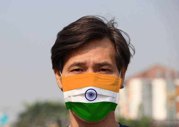 India flag on hygienic mask. Masked Asian man prevent germs. concept of Tiny Particle protection or virus corona. stock photo