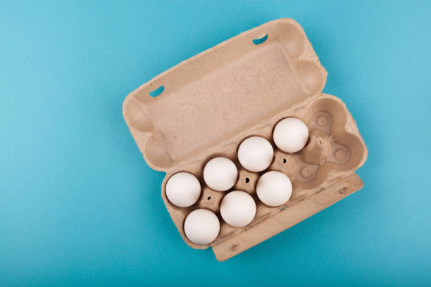 istock Egg Chicken eggs. Top view of an open gray box with white eggs. Isolated on a blue background. The concept of a healthy lifestyle, getting pure protein. Proper Breakfast. Seven eggs 1210231949