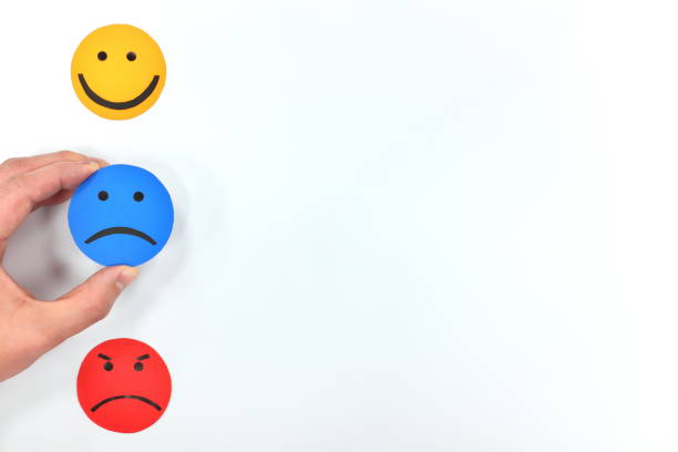 istock Happy, sad and angry face emoticons in white background. Hand choosing sadness. Customer satisfaction and feedback concept. 1210231961