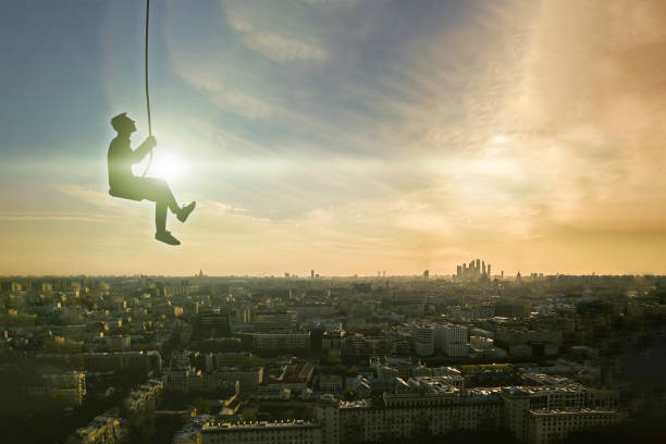 istock flying high in the sky with clouds, man on a swing, relax and dream in mind concept 1210232277