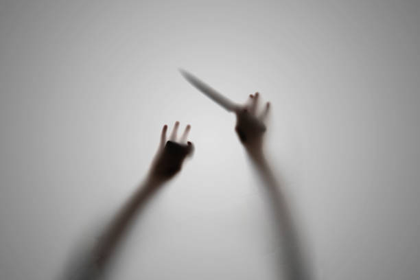 une silhouette sombre d’une personne sombre tenant un couteau, concept d’horreur cauchemardesque, flou hors foyer - death fear focus on shadow isolated objects photos et images de collection