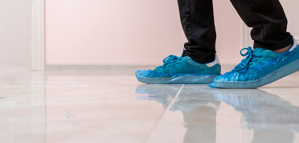 hospital patient visitor walking in the shoe covers to protect hygiene on the floor