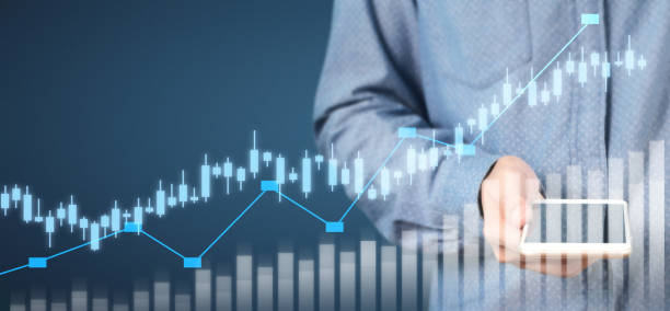 istock Hand holding smartphone device and touching screen. Stock exchange market concept 1210233337
