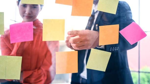 Business couple   meeting at office and use post it notes to share idea.