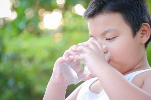 istock Boy drinking water in the morning 1210236752