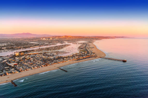Newport Beach Aerial A wide angle view of the entire Newport Beach area including the harbor and Newport Beach Pier shot from an altitude of about 2000 feet over the Pacific Ocean at dusk. newport beach stock pictures, royalty-free photos & images