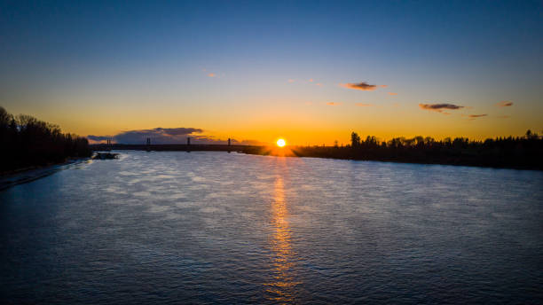 istock Aerial of sun setting over river bridge in the background 1210248130