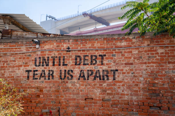 istock Until debt tear us apart message spray painted political protest message on brick wall 1210248201