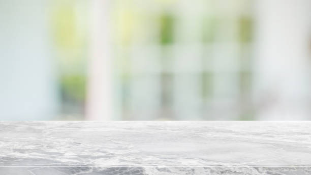 istock Empty white stone marble table top and blurred of interior restaurant with window view green from tree garden background background - can used for display or montage your products. 1210249525