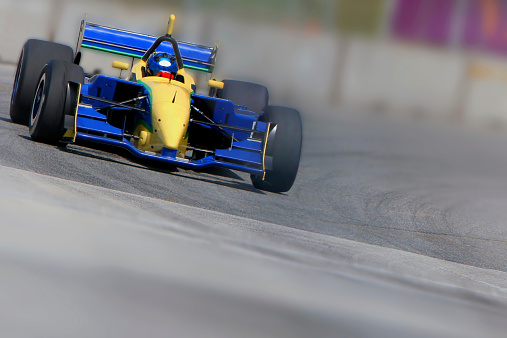 Open wheeled single-seater race car in a corner with limited depth of field