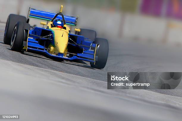 Blue And Yellow Racecar In Motion On A Racetrack Stock Photo - Download Image Now - Racecar, Engine, Skidding