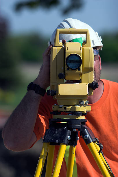 istock Man looking through surveying equipment 121025030