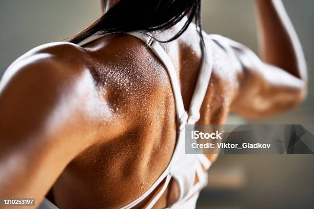 Close Up Of Woman Back With Flexing Her Muscles Stock Photo