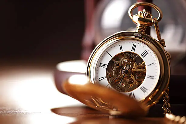 Photo of Gold pocket watch and hourglass
