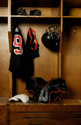 Traditional American football locker room with gear.