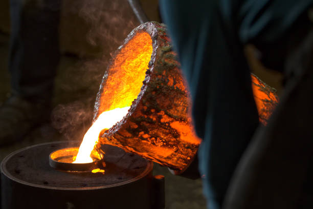 Molten bronze poured into mold by melter in foundry workshop Old metal craftwork : Molten bronze poured into mold by melter in foundry workshop, lost tradition melting metal stock pictures, royalty-free photos & images