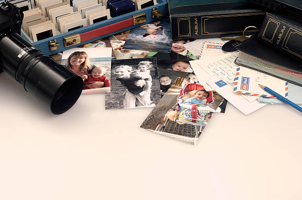 Collection of old vintage black and white photographs on a table showing the idea of nostalgia, time, memories and the past