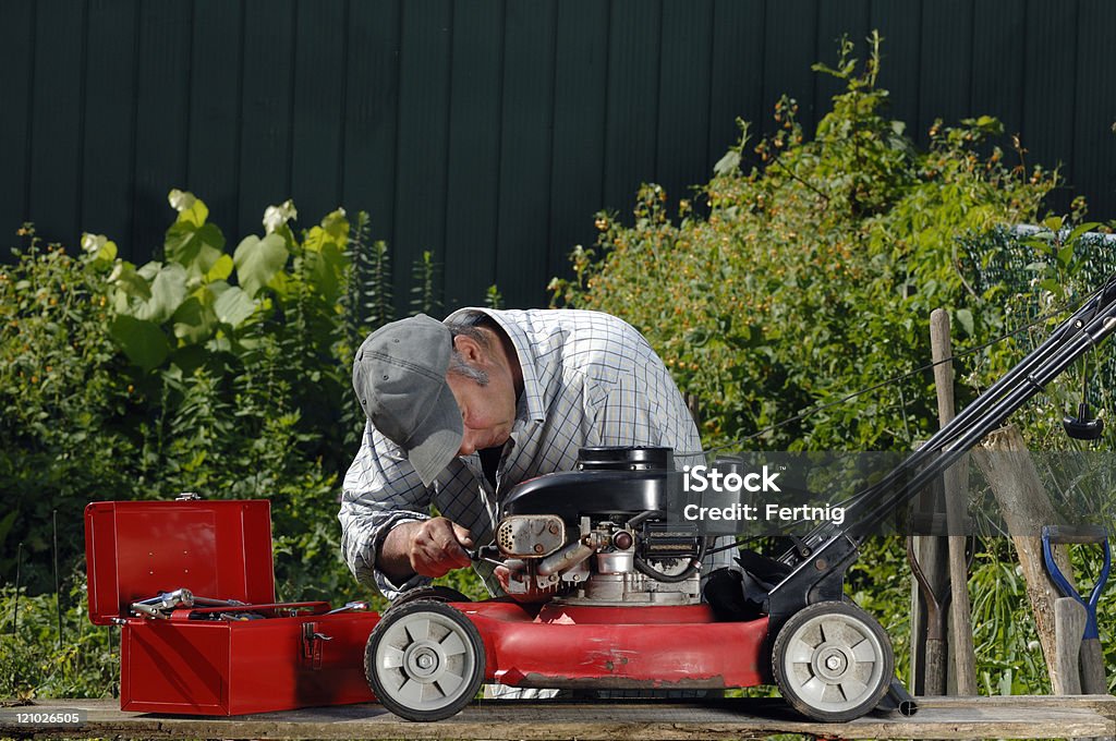 Człowiek pracy na lawnmower - Zbiór zdjęć royalty-free (Kosiarka do trawy)