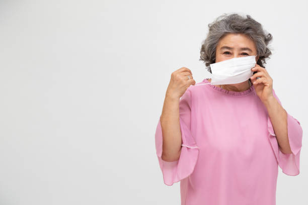 Asian senior woman wearing a protective face mask for plague coronavirus or covid-19 infectious disease. Facial hygienic mask for safety outdoor environmental awareness or virus spread concept mujer de la tercera edad asiática que lleva una mascarilla protectora para coronavirus de la peste o enfermedad infecciosa de cóvido-19. máscara higiénica facial para la conciencia ambiental al aire libre de seguridad o concepto de propagación de viru