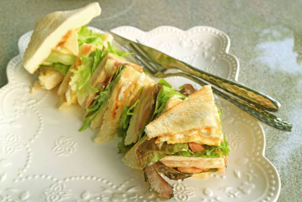 istock Tasty Cheesy Ham and Egg Sandwich on a White Plate 1210266834