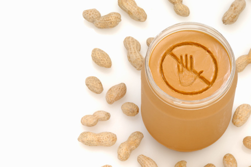 A concept photograph of a no entry or prohibited sign really engraved into a jar of peanut butter.  Ideal for peanut allergy warnings.