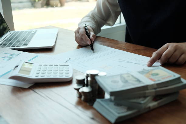 istock Businessman analyzing investment charts and pressing calculator buttons over documents. Accounting Concept  Saving Economy concept. 1210268001