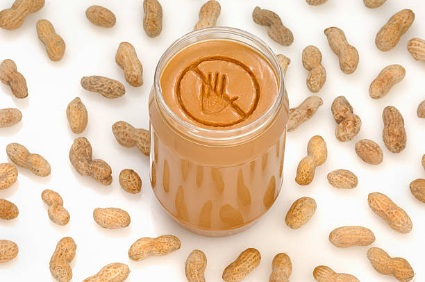 Peanut allergy A concept photograph of a no entry or prohibited sign engraved into a jar of peanut butter.  Ideal for peanut allergy warnings. food allergies stock pictures, royalty-free photos & images