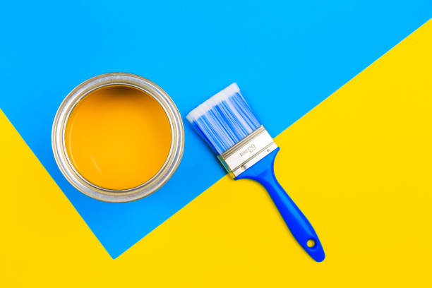 istock Yellow  Paint Can with Brush Top View On multicolor Background. 1210268512