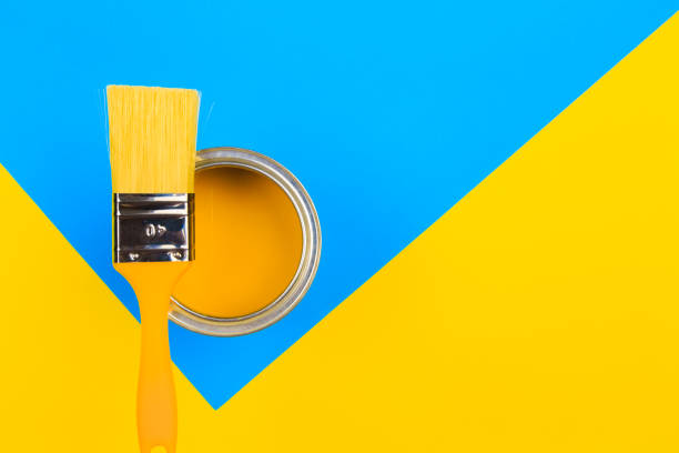 istock Yellow  Paint Can with Brush Top View On multicolor Background. 1210268694