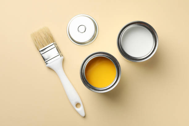 istock Paint cans and brush on beige background, top view 1210269202