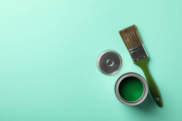 istock Paint can and brush on green background, top view 1210269343