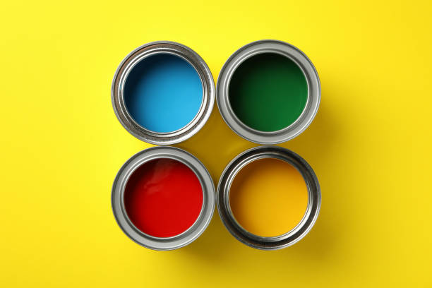 istock Cans with different paint on yellow background, top view 1210269423
